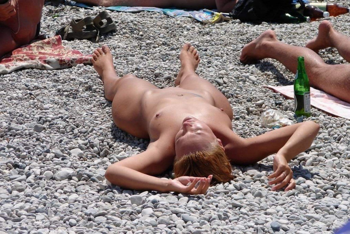 Голая девушка ест персики голышом на пляже